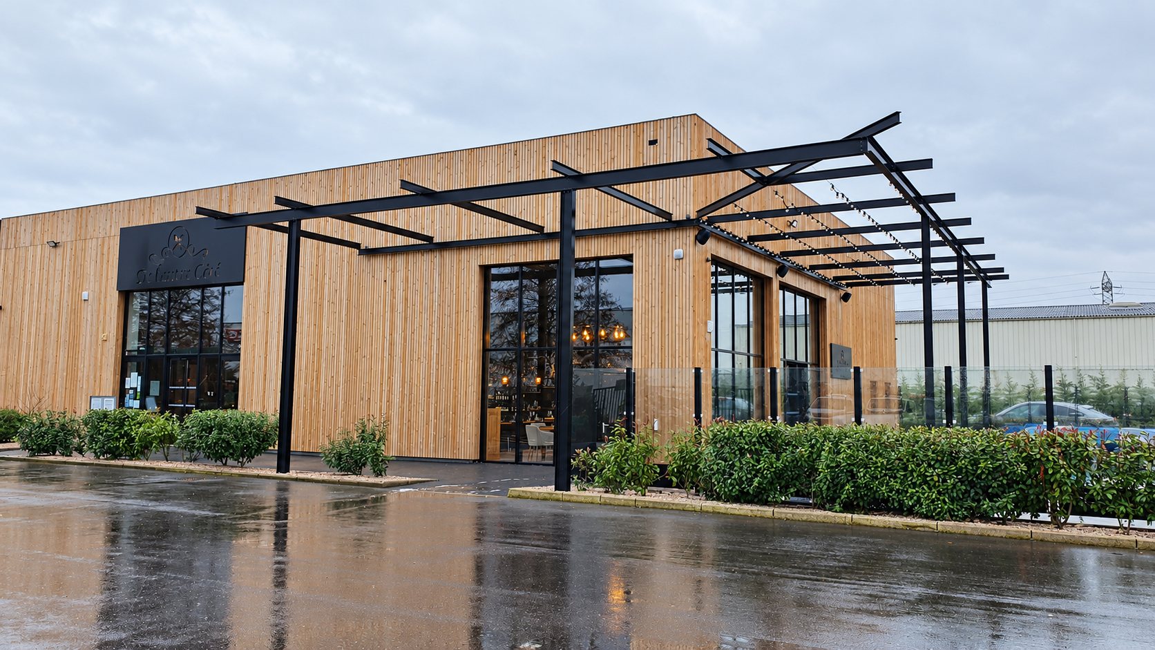 Bâtiment à bardage bois, pergola métallique et grands vitrages