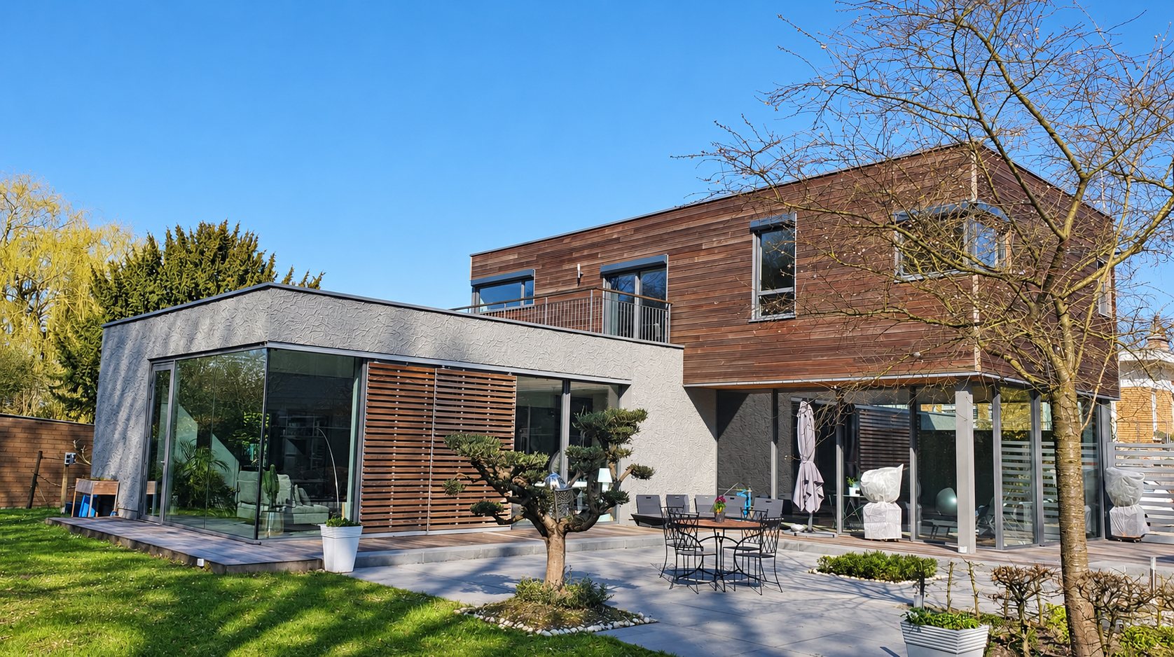 Maison moderne à bardage bois et grandes baies vitrées donnant sur le jardin